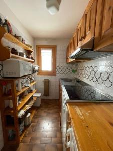 利维尼奥Appartamento Rin, Livigno的厨房配有木制橱柜和台面