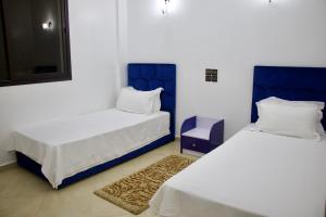 马拉喀什Magnifique Duplex à Marrakech的蓝色和白色的客房内的两张床