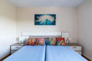 塞维利亚Miraflores Luxury Suites的一间卧室配有蓝色的床和色彩缤纷的枕头