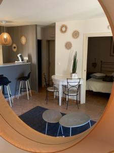 索马讷-德沃克吕兹appartement cosy avec climatisation réversible GOLF DE SAUMANE的客厅配有桌椅和镜子