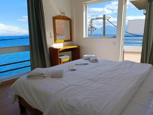 阿基欧斯尼古拉斯9 Muses Apartments的一间卧室设有一张床,享有海景