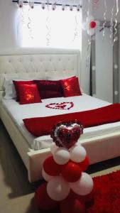 巴兰基亚Hostal Sabanero的一间卧室配有红色和白色枕头的床