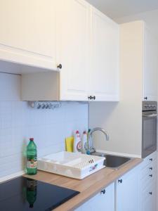 佩奇Pajger Apartman Egyetemváros的厨房配有白色橱柜和水槽