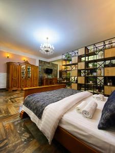 埃里温Shirbakyan Boutique Hotel & Apartments的一间卧室配有一张大床和一个吊灯。
