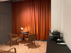 米兰Ritorno alle origini Suites的橙色窗帘、桌子和椅子的房间