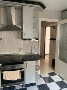 拜纳Apartamento Al Andalus的厨房配有水槽和炉灶 顶部烤箱
