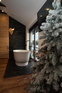 亚布卢尼齐亚Chillax Chalet的一间带圣诞树和浴缸的浴室