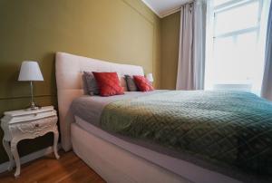 维也纳Mint 13 @ Mariahilf的一间卧室配有一张带红色枕头的床和一扇窗户