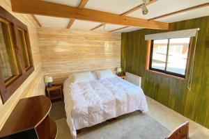 拉斯特朗卡斯MI Lodge Las Trancas Hotel & Spa的一间卧室设有一张床和木墙