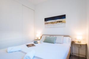 塞维利亚Apartmentos Marqués de Nervion的卧室配有白色的床和2张桌子