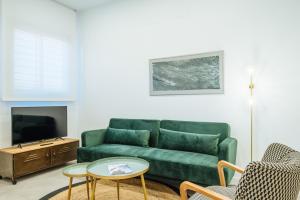 塞维利亚Apartmentos Marqués de Nervion的客厅配有绿色沙发和桌子