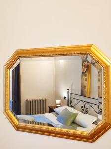 米兰il Sole di Baggio的墙上的镜子,房间里的床