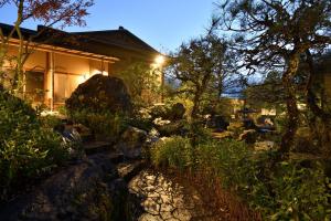 伊豆Oni no Sumika的一座房子,里面有一个石头和树木的院子