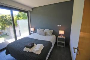 吉尔斯Apartamento Lobo - Casas Barca do Rio - Geres的一间卧室设有一张床和一个大窗户