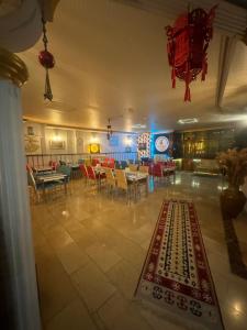 科尼亚MEVLANA ŞEMS HOTEL的一间设有桌椅和地毯的餐厅