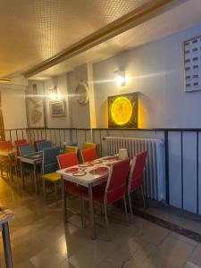 科尼亚MEVLANA ŞEMS HOTEL的餐厅设有桌椅和墙上的时钟