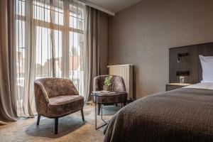 克诺克－海斯特布里塔尼亚酒店的酒店客房带一张床、椅子和窗户