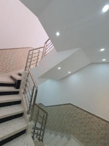 胡塞马Al Hoceima Ajdir Maroc - Maison 5 chambres 10 personnes的白色天花板的建筑里设有一套楼梯