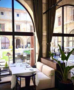 莱昂圣依西多禄皇家教堂酒店的一间带桌子和大窗户的用餐室