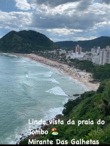瓜鲁雅Apto 1 suíte a 30 mts. da Praia do Tombo - Guarujá的一群人欣赏海滩美景