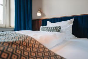 兰茨胡特Hotel Amalia - Boutique Hotel的一间卧室配有带白色床单和枕头的床。