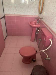 巴加Hotel Ocean Face, BAGA的粉红色的浴室设有粉红色的卫生间和水槽