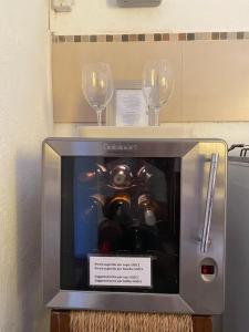 科洛尼亚-德尔萨克拉门托Casa Calma的两杯酒杯和一台带机器的小电视