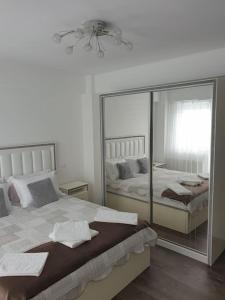 锡比乌Leaf House的一间卧室设有两张床和大镜子