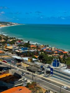 纳塔尔Janastí Suítes Praia de Ponta Negra的城市和海洋的空中景观