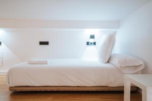 塞维利亚apartamentos montevideo 6的一张带白色床单和枕头的床