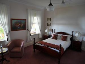 GretaLeconfield House的卧室配有床、椅子和窗户。