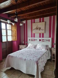 奧瑞那La Torruca的一间卧室配有一张粉色和白色条纹的床