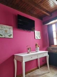 奧瑞那La Torruca的客房内的粉红色墙壁和白色桌子