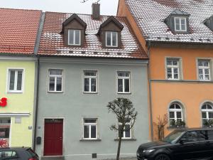 福恩施特劳斯VOH Exklusives Wohnhaus MITTEN in Vohenstrauß, bis 8 Personen!!!的一群有红色门和屋顶的房屋
