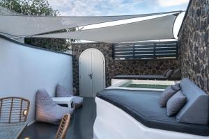 卡特瑞杜斯Sun Naam Home Santorini with heated jacuzzi的一张床和一个带热水浴缸的庭院