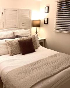 布里斯班Jacaranda House Garden Suite的一间卧室配有两张带白色床单的床