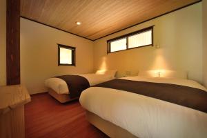 水上町尚文旅馆的一间卧室设有两张床和两个窗户。