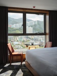 釜山Hotel tt Gupo的酒店客房设有一张床和一个大窗户