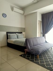 米里BS City Homestay2 - Miri Times Square的一间卧室配有一张床和一张沙发