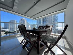 埃斯特角城Miami Boulevard II excelente, a 100 metros del mar的餐桌、两把椅子和大窗户