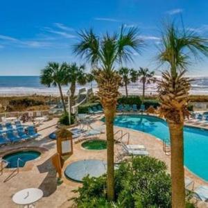 默特尔比奇Sea Watch Resort的拥有游泳池、棕榈树和海滩的度假酒店