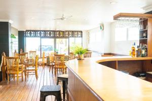 普卢坎Arton Resort & Beach Club的餐厅设有酒吧,配有木桌和椅子