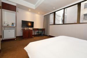 台北上格大饭店的一间卧室配有一张床和一台平面电视