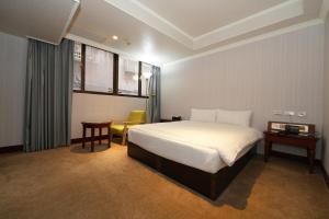 台北上格大饭店的卧室配有1张床、1张桌子和1把椅子