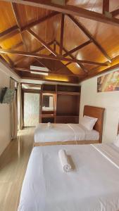 Tjolomaduchrome hotel & resort solo的一间卧室设有两张床和木制天花板