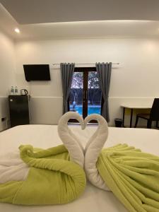 Tjolomaduchrome hotel & resort solo的一张有两只天鹅的床铺,使人心中