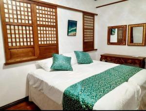 MalabañasBALÉ的卧室配有带蓝色枕头的大型白色床