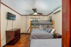 罗阿坦Exclusive Full House - 3 BDRM & 3 BATH - 3min Beach的一间卧室配有两张床和吊扇