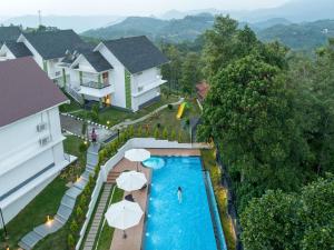 蒙纳Sprise Munnar Resort and Spa的享有带遮阳伞的度假村游泳池的空中景致