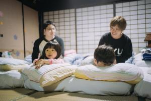 仙北Stay and Discover Nishinoya的一群儿童在房间里玩床